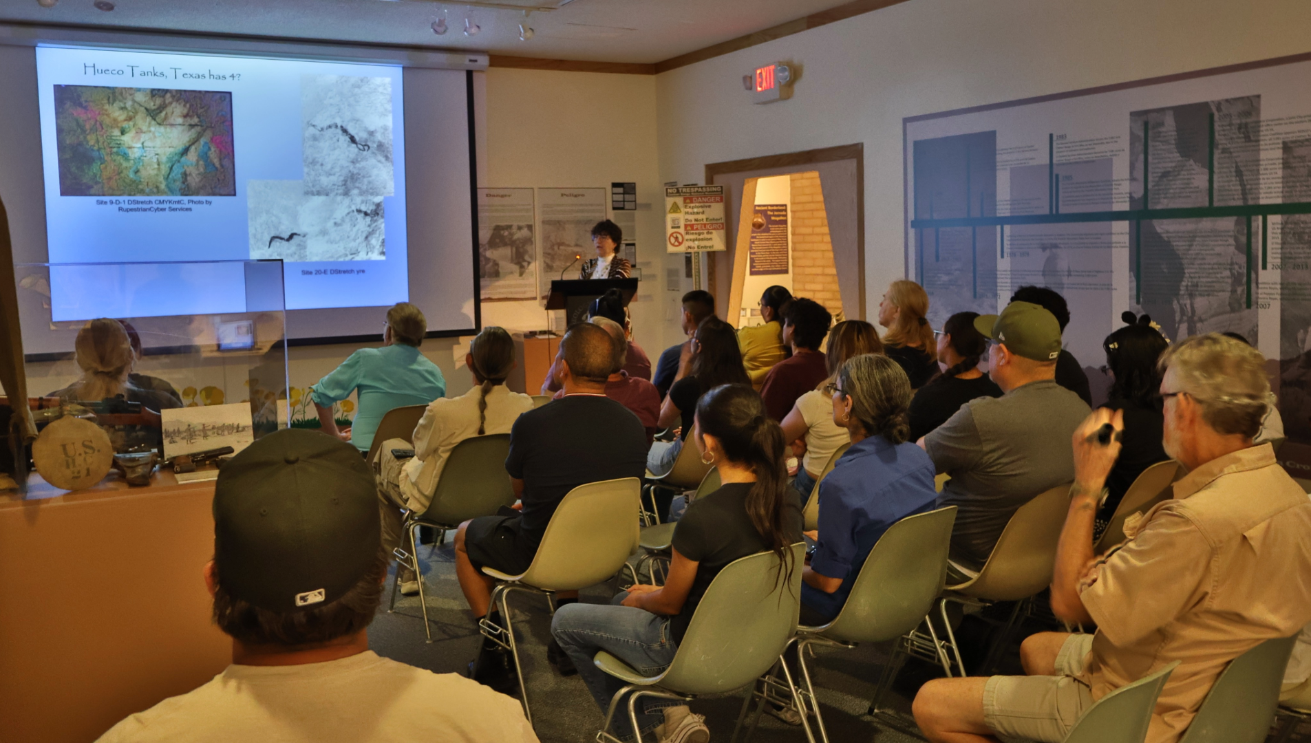 People sitting in auditorium looking at screen